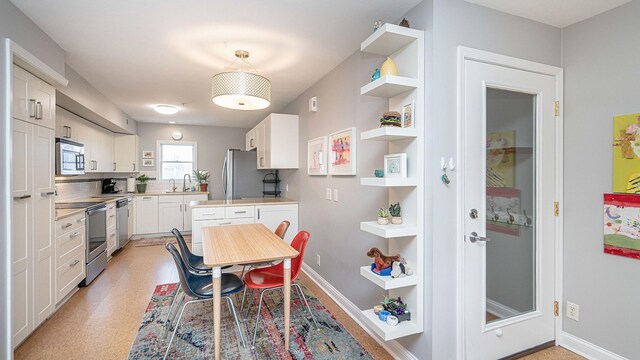 560 Little Lake Dr Unit 19, Ann Arbor, MI 48103 - kitchen with appliances with stainless steel finishes, a sink, white cabinetry, light countertops, and open shelves