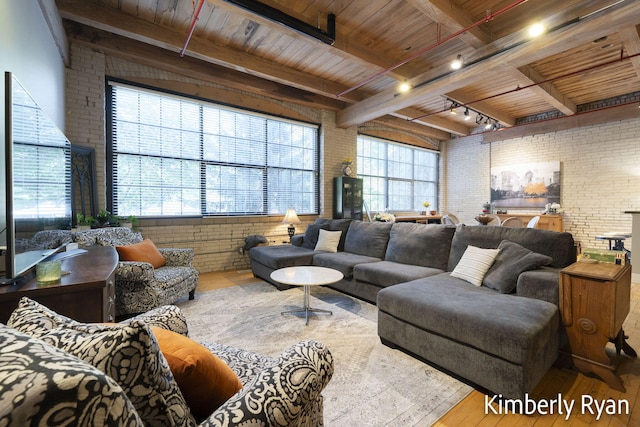 living room with beamed ceiling, wood-type flooring, wooden ceiling, and brick wall