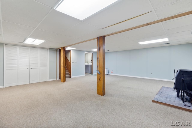 basement with light carpet and a drop ceiling