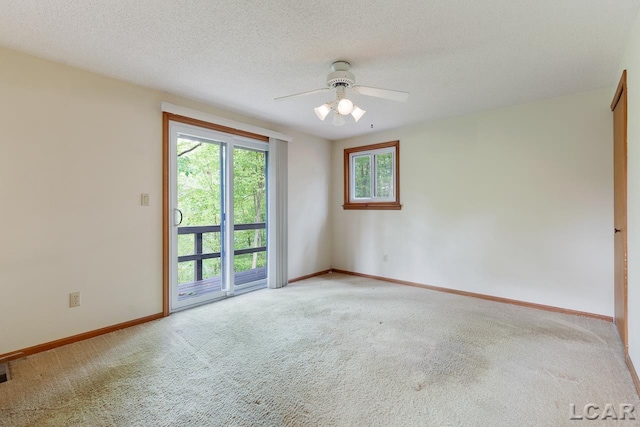 carpeted spare room with ceiling fan and a textured ceiling