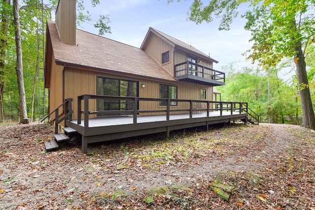 rear view of house with a balcony and a wooden deck