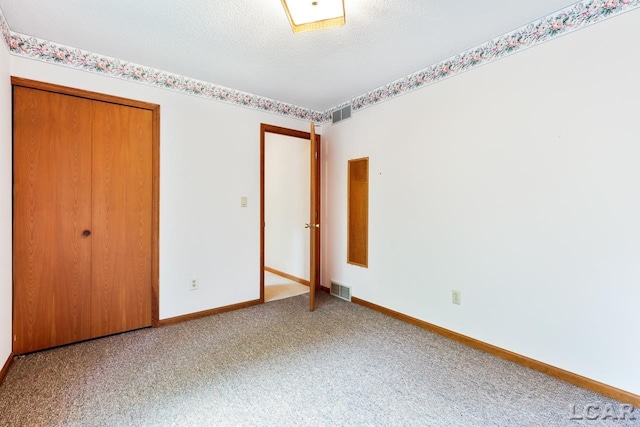 unfurnished bedroom featuring a closet, carpet, and a textured ceiling