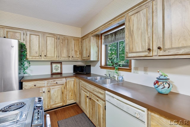 kitchen featuring hardwood / wood-style floors, sink, a textured ceiling, light brown cabinetry, and stainless steel appliances