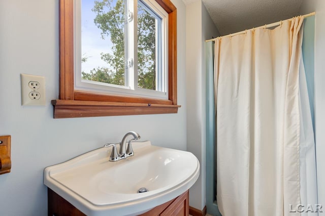 bathroom with sink, a textured ceiling, and a shower with shower curtain