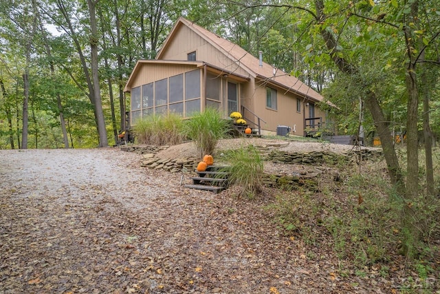 view of home's exterior with a sunroom and central AC