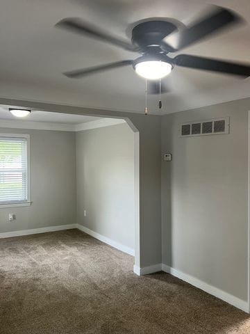 carpeted spare room with ceiling fan