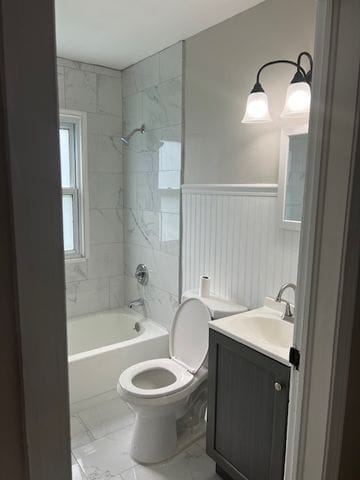 full bathroom featuring toilet, vanity, and tiled shower / bath