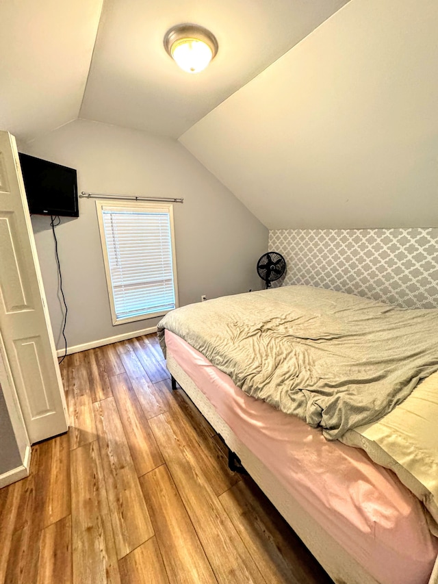 bedroom with wood-type flooring and lofted ceiling