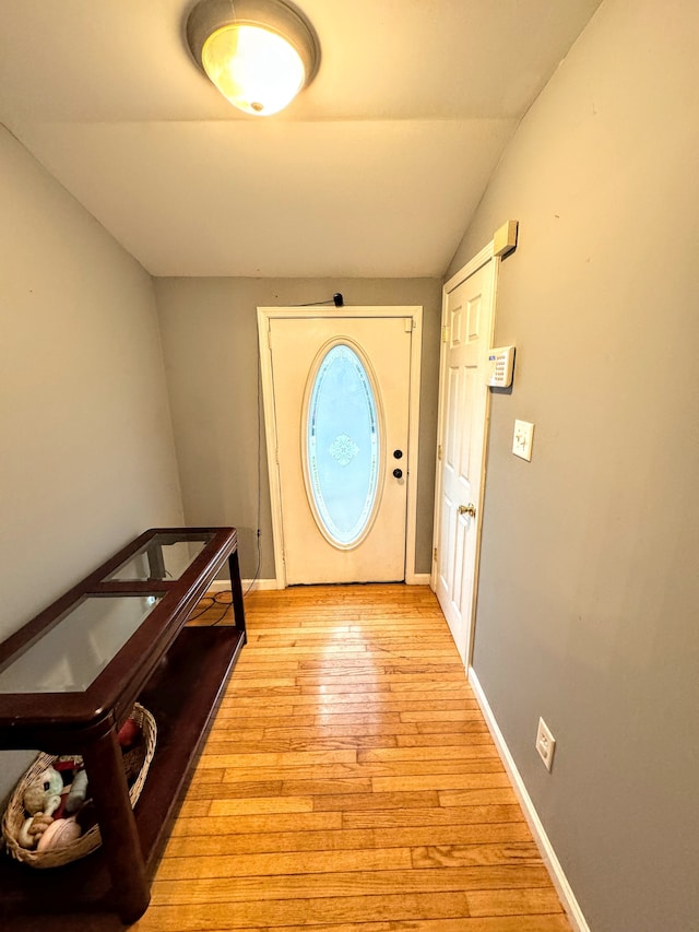 entryway featuring lofted ceiling and light hardwood / wood-style flooring