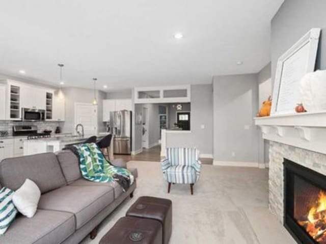 living room with a stone fireplace and sink