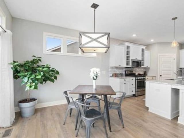 dining area featuring light wood-type flooring and sink