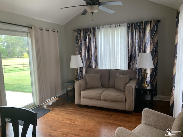 living room with hardwood / wood-style floors, ceiling fan, and lofted ceiling