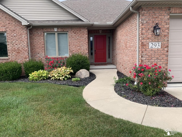 doorway to property featuring a lawn