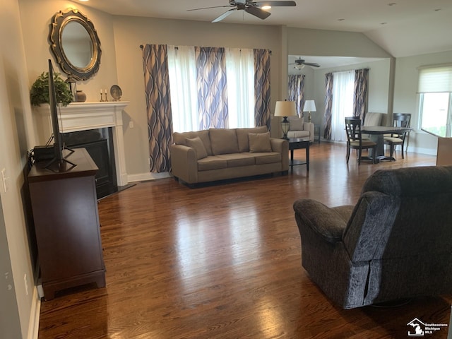 living room with ceiling fan, dark hardwood / wood-style flooring, and vaulted ceiling