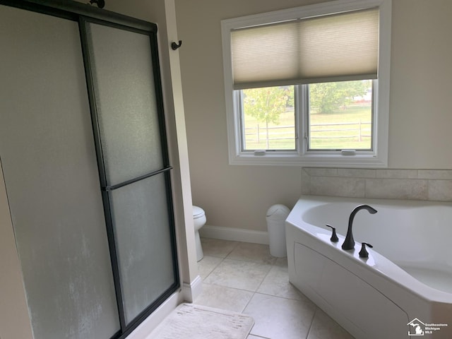 bathroom with tile patterned floors, toilet, and a bathing tub