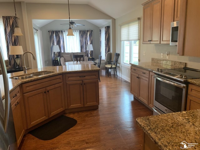 kitchen featuring sink, dark hardwood / wood-style floors, pendant lighting, lofted ceiling, and appliances with stainless steel finishes