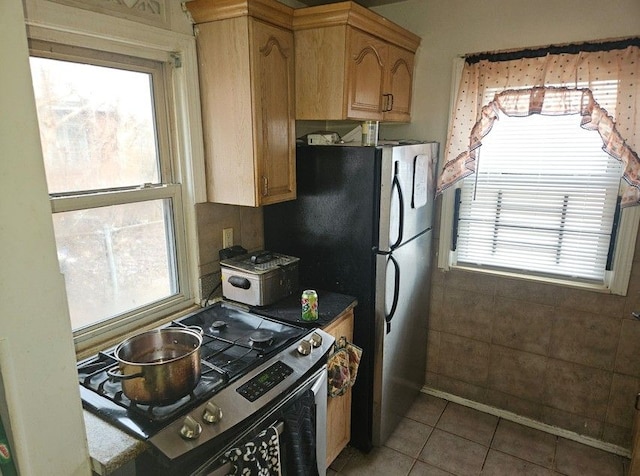 kitchen with dark countertops, stainless steel range with gas cooktop, and tile patterned floors