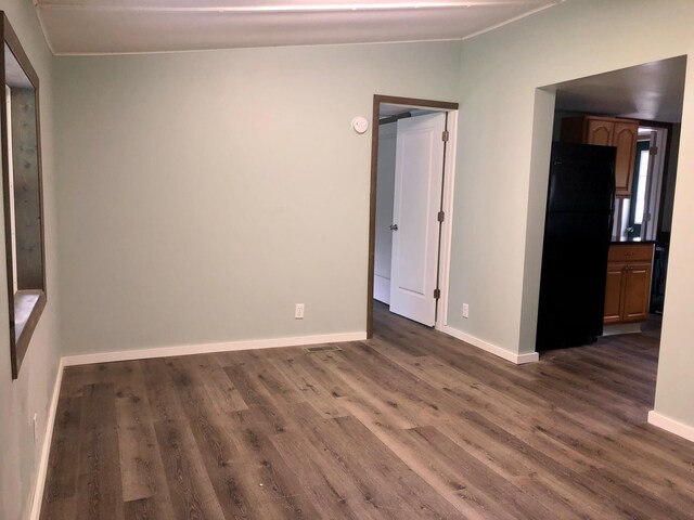 6566 E Stolberg Rd, Fountain, MI 49410 - empty room with dark wood-style flooring, baseboards, and crown molding