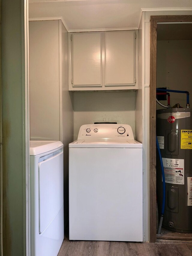 6566 E Stolberg Rd, Fountain, MI 49410 - washroom featuring water heater, washer and dryer, cabinet space, and wood finished floors