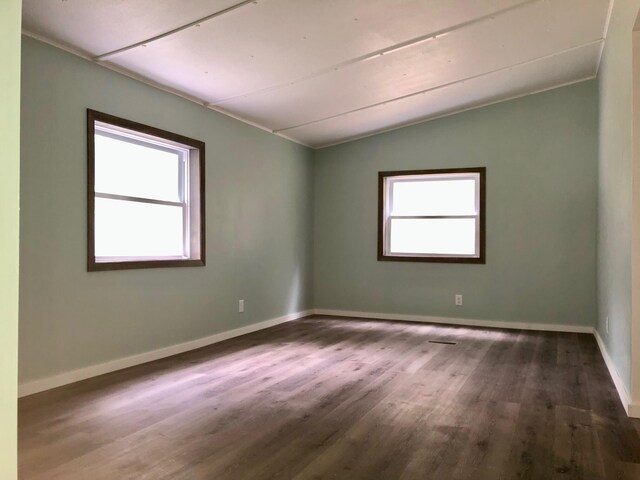 6566 E Stolberg Rd, Fountain, MI 49410 - empty room featuring plenty of natural light, wood finished floors, vaulted ceiling, and baseboards