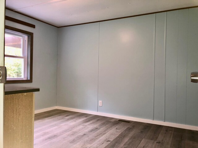 6566 E Stolberg Rd, Fountain, MI 49410 - unfurnished room with wood finished floors, baseboards, a decorative wall, and crown molding