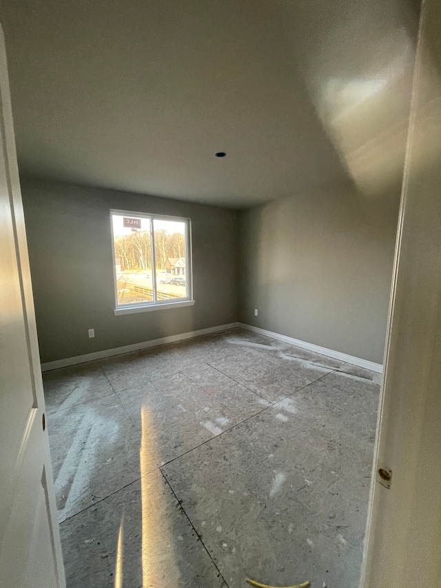 spare room with baseboards