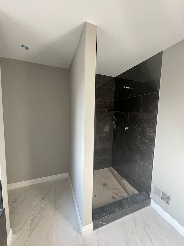 full bath with visible vents, baseboards, marble finish floor, and a tile shower