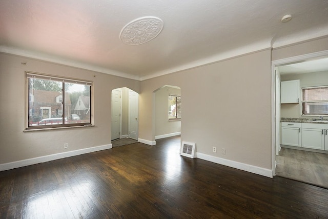 unfurnished living room featuring a wealth of natural light, sink, and dark hardwood / wood-style floors