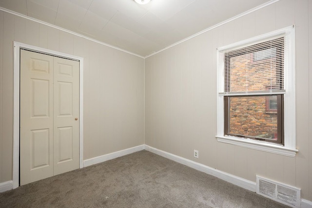 carpeted spare room with crown molding