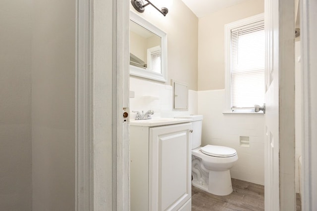 bathroom featuring hardwood / wood-style floors, a healthy amount of sunlight, tile walls, and toilet