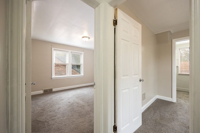 hallway featuring carpet floors and vaulted ceiling