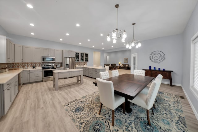 dining area with a chandelier and light hardwood / wood-style flooring