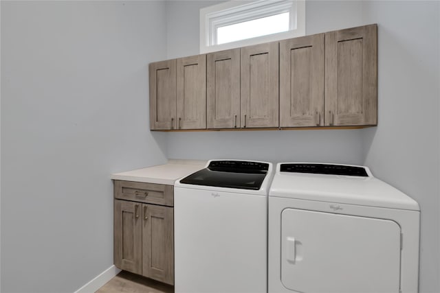 laundry room featuring washer and dryer and cabinets