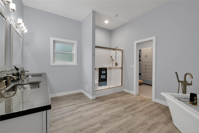 bathroom featuring plus walk in shower, wood-type flooring, and vanity