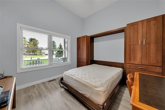 bedroom with vaulted ceiling and light hardwood / wood-style flooring