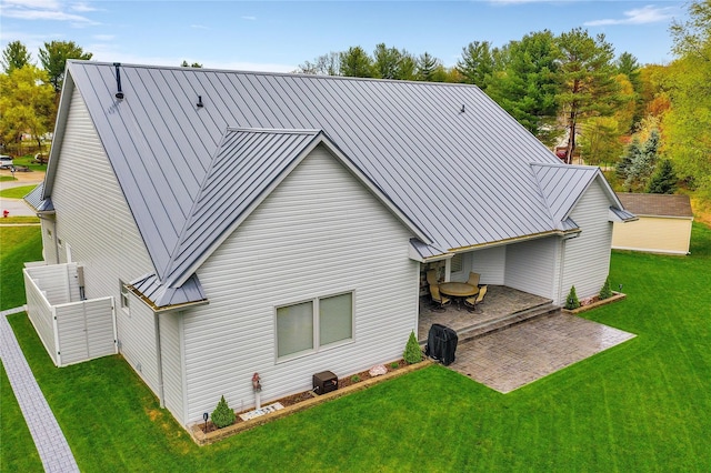 rear view of property featuring a lawn and a patio area