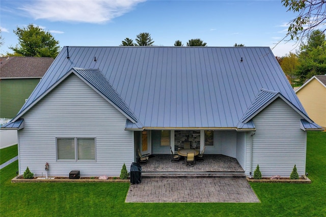 rear view of property with a yard and a patio