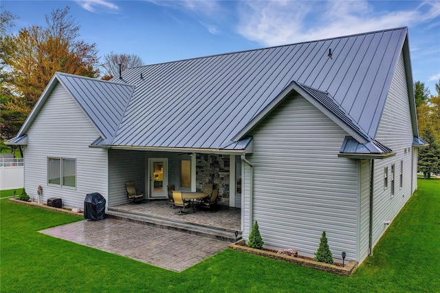 rear view of property featuring a patio area, ceiling fan, and a yard