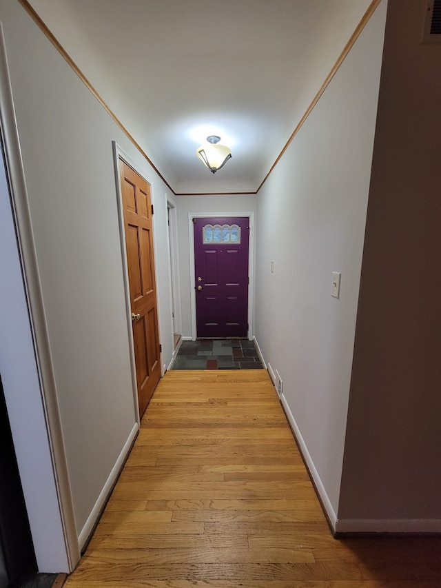 doorway to outside with light wood-type flooring and ornamental molding