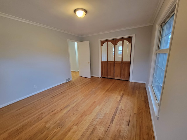 interior space with a closet, light hardwood / wood-style floors, and ornamental molding