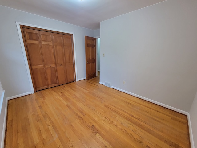 unfurnished bedroom featuring a closet and light wood-type flooring