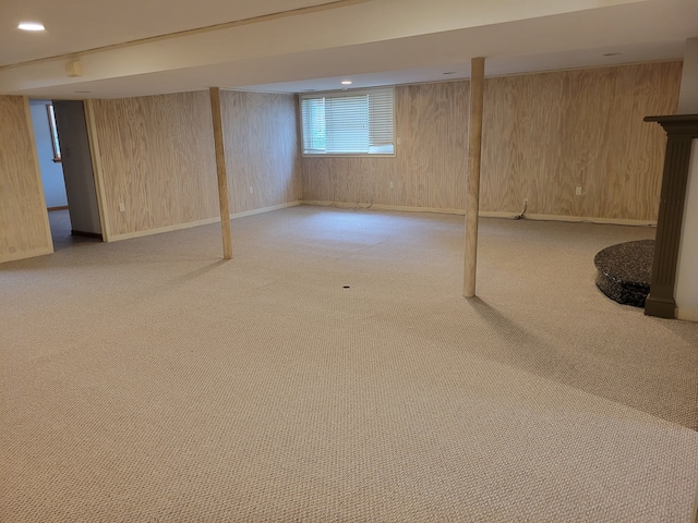 basement featuring wood walls and light carpet