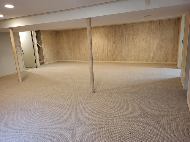 basement with wood walls and light carpet