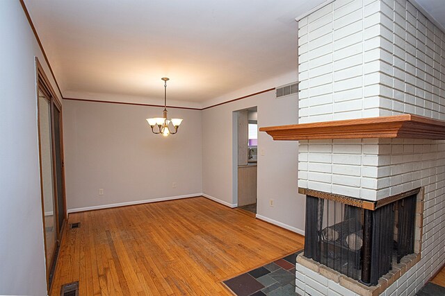31990 Nottingwood St, Farmington Hills, MI 48334 - unfurnished living room featuring a chandelier, hardwood / wood-style floors, a brick fireplace, and baseboards