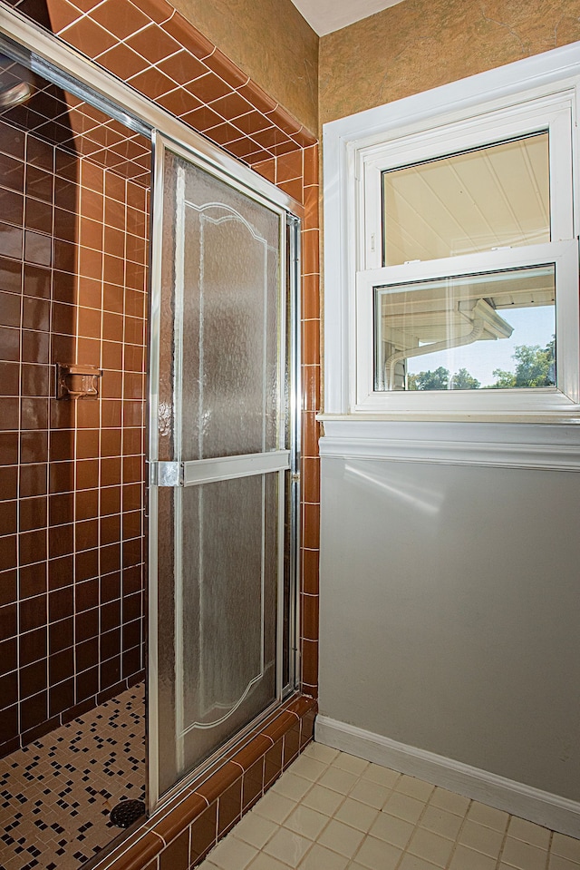 bathroom with tile patterned floors and a shower with door