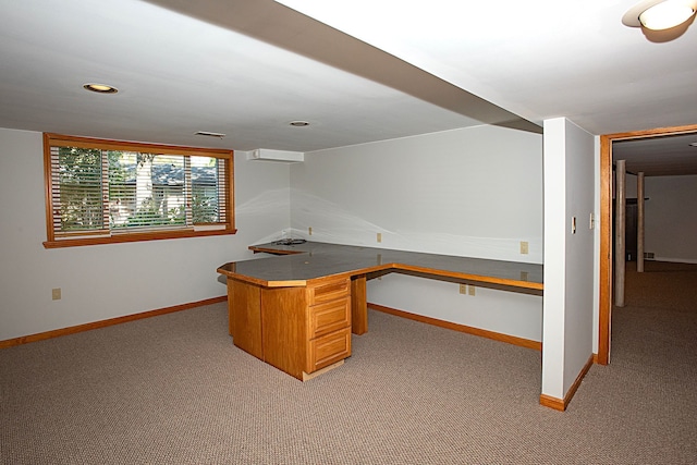 unfurnished office featuring built in desk and light colored carpet