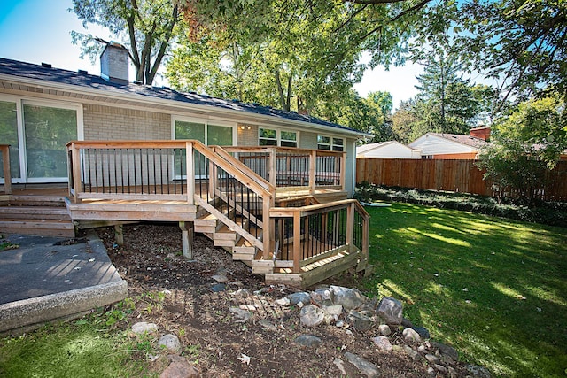 rear view of house with a deck and a lawn