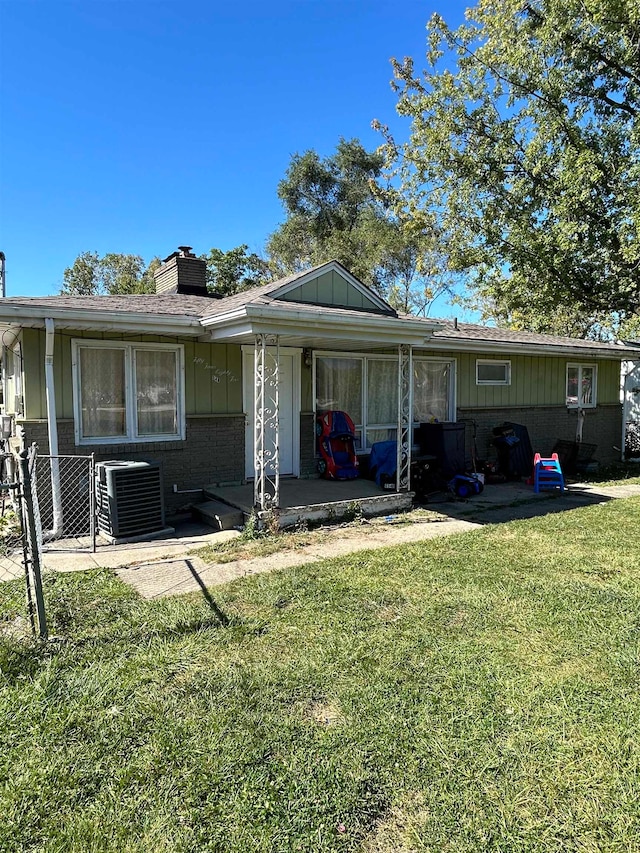 view of front facade featuring a front yard and central AC