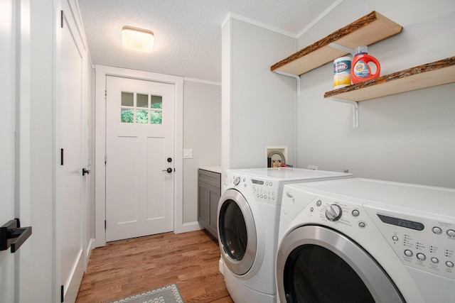 laundry area with cabinets, independent washer and dryer, crown molding, a textured ceiling, and light wood-type flooring