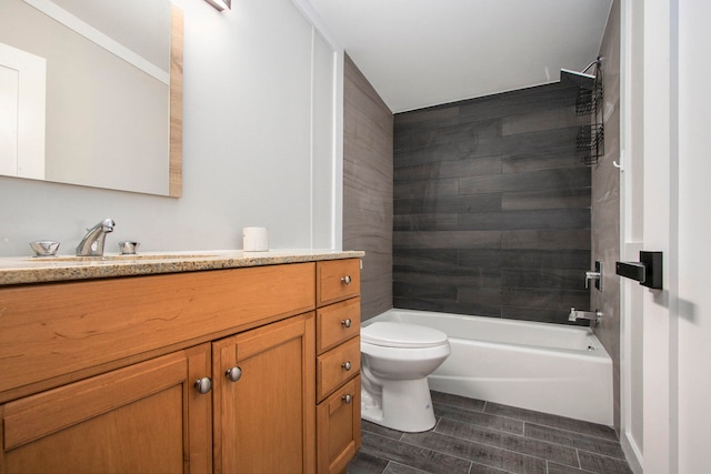 full bathroom featuring vanity, tiled shower / bath combo, and toilet